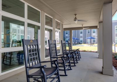 Outdoor seating area with rocking chairs and shaded patio