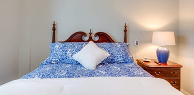Cozy bedroom with a floral comforter and lamp