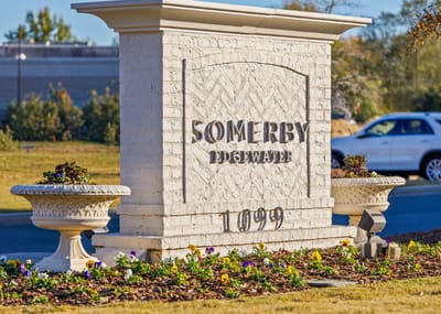 Sign for Somerby Edgewater with landscaped flowers