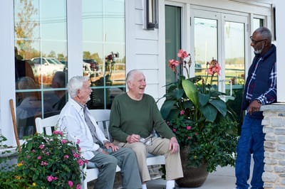 Residents conversing on a bench near the entrance