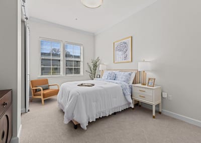 Brightly decorated resident room with a bed and window