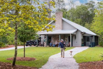 A resident walking a dog near the facility building