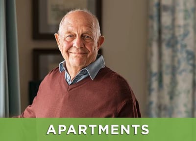 An elderly man smiling in an apartment interior