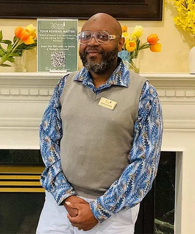 Staff member posing in a welcoming lobby area