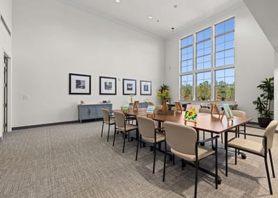 Bright common area with a large table and plants
