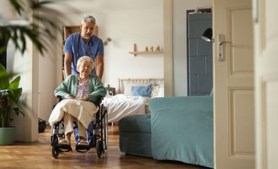 A nurse assisting an elderly woman in a wheelchair