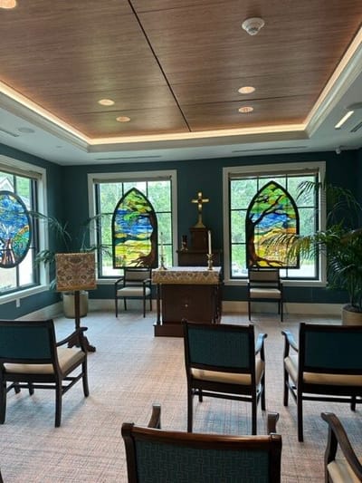 Interior view of a quiet chapel with stained glass windows