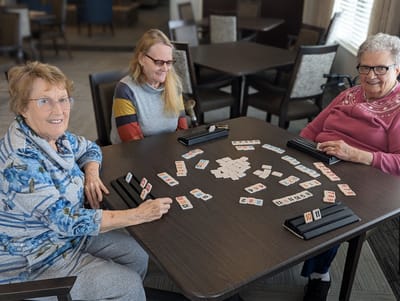 Three residents playing a game together at a table