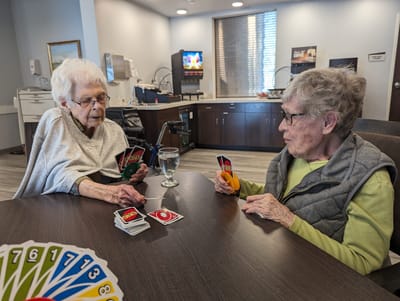 Residents playing a card game in a common area