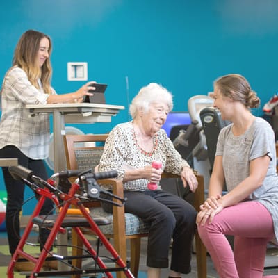 Dow Rummel Village, nursing home in Sioux Falls, SD — Engaged elderly resident interacting with staff in activity room