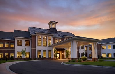 Exterior view of a serene assisted living facility at sunset