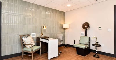 Interior corner of a serene sitting area with chairs and a lamp