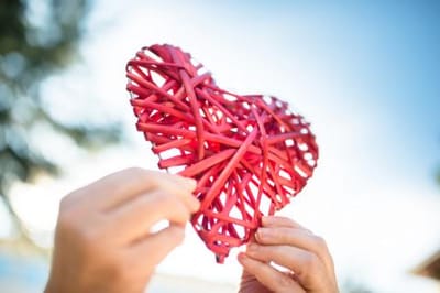 A handmade red heart crafted from woven material