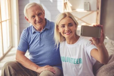 Resident and volunteer taking a selfie indoors