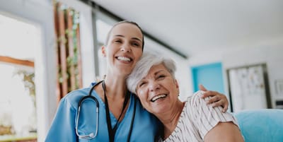 Resident and staff member smiling together in a common area