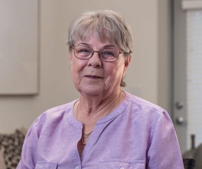 A smiling resident in a light-colored room