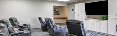 Interior view of a common area with recliners and a TV