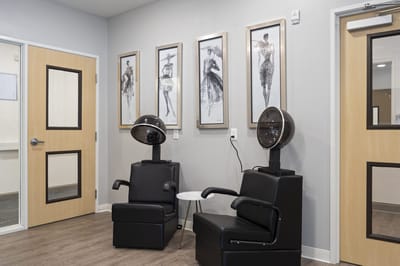 Interior salon area with styling chairs and artwork