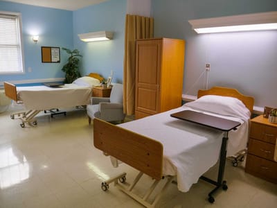 Two hospital beds in a shared patient room