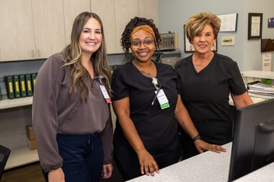 Staff members smiling at the reception desk