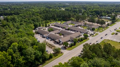 Aerial view of a senior living facility with green surroundings