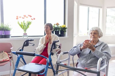 Two residents clapping during an activity session