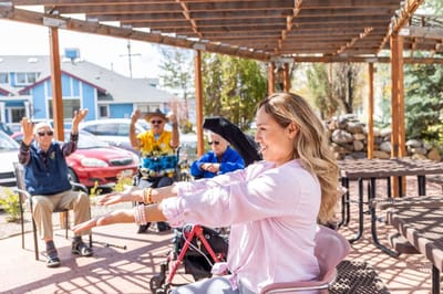 Residents participating in a chair exercise class outdoors