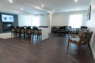 Bright common area with seating and presentation screen