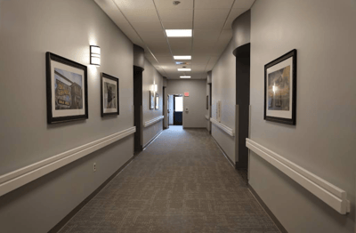 Brightly lit corridor with framed artwork on the walls