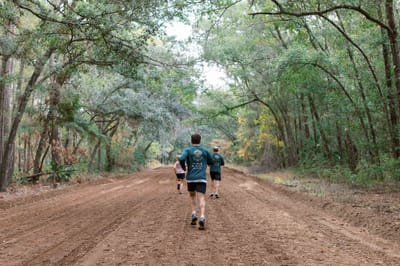 Residents jogging along a wooded path