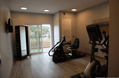 Bright fitness room with exercise equipment and a balcony view