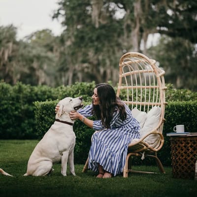Woman interacting with a dog in a garden setting