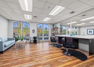 Interior view of a salon area with chairs and large windows