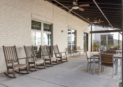 Outdoor patio area with rocking chairs and tables