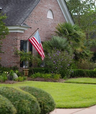 Exterior view of a facility with an American flag and landscaping