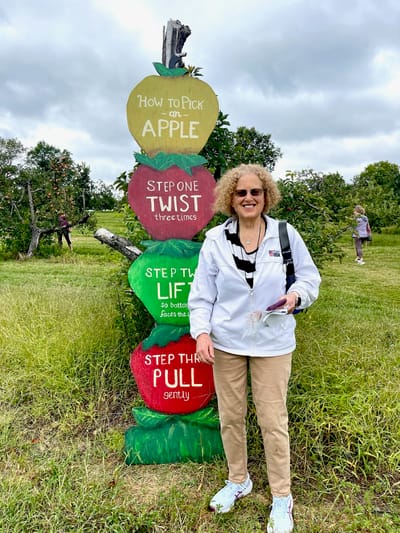 Resident participating in an outdoor apple picking activity