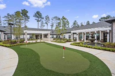 Outdoor putting green with landscaping and seating