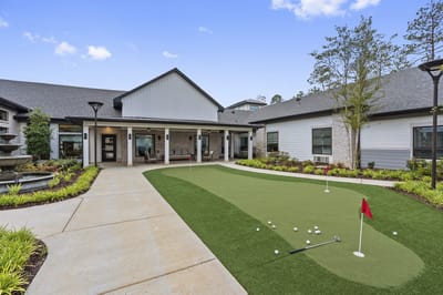 Exterior view of a senior living facility with a putting green.