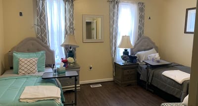 A shared resident room with two beds and natural light