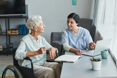A caregiver helping a resident in a bright room