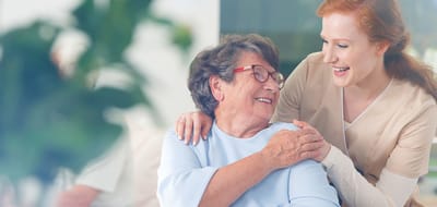 Caregiver and resident sharing a joyful moment in a common area