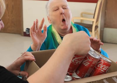Resident reacting joyfully while receiving Coca-Cola cans