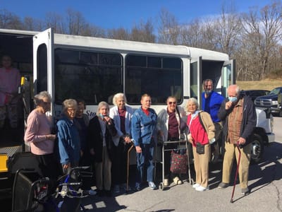 Residents boarding a facility shuttle bus outdoors
