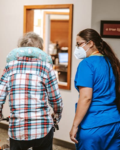 A staff member assisting a resident in an interior setting