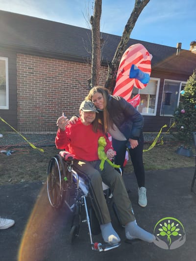 A resident and staff member celebrating outdoors with festive decor