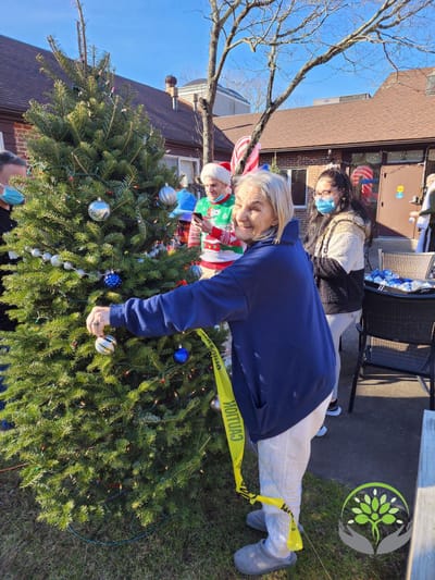 Residents decorating a Christmas tree outdoors