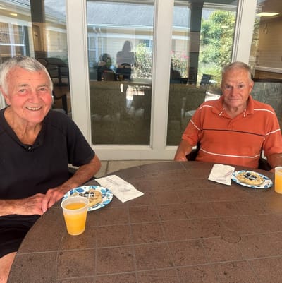 Two residents enjoying snacks outdoors