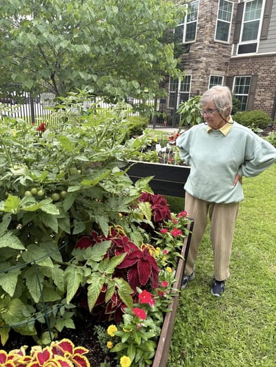 Resident tending to a garden filled with flowers and plants
