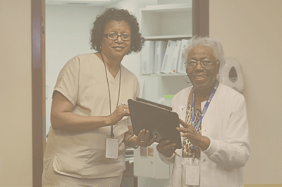 Staff member assisting a resident with a tablet