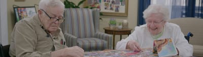 Residents enjoying a puzzle together in an activity room